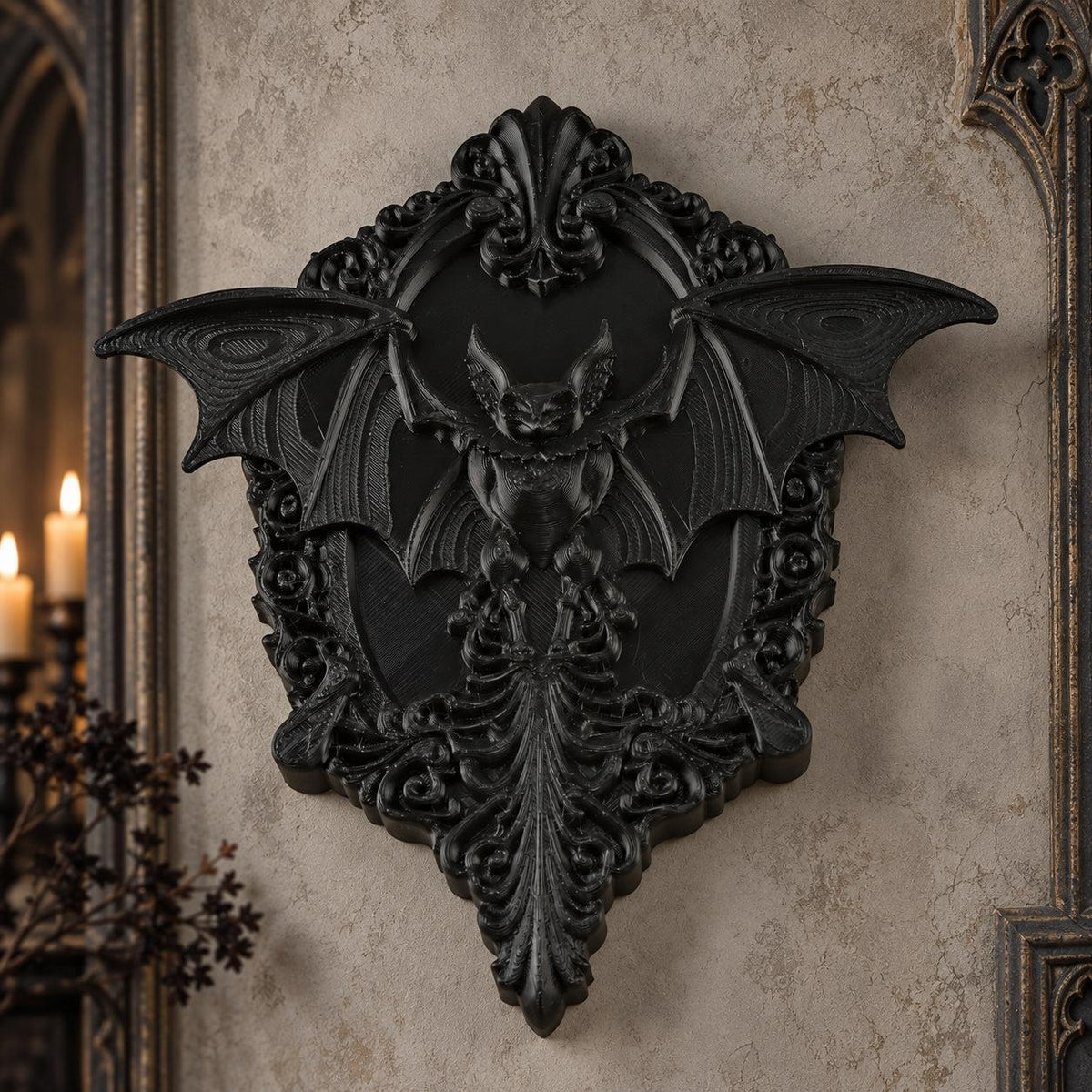 Black gothic bat relief wall plaque with detailed baroque carving on a light vintage wall