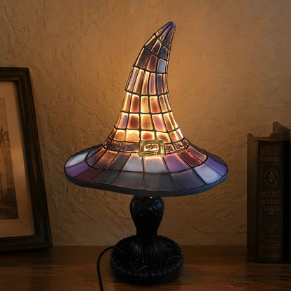 Stained glass witch hat night light on nightstand with framed picture and books