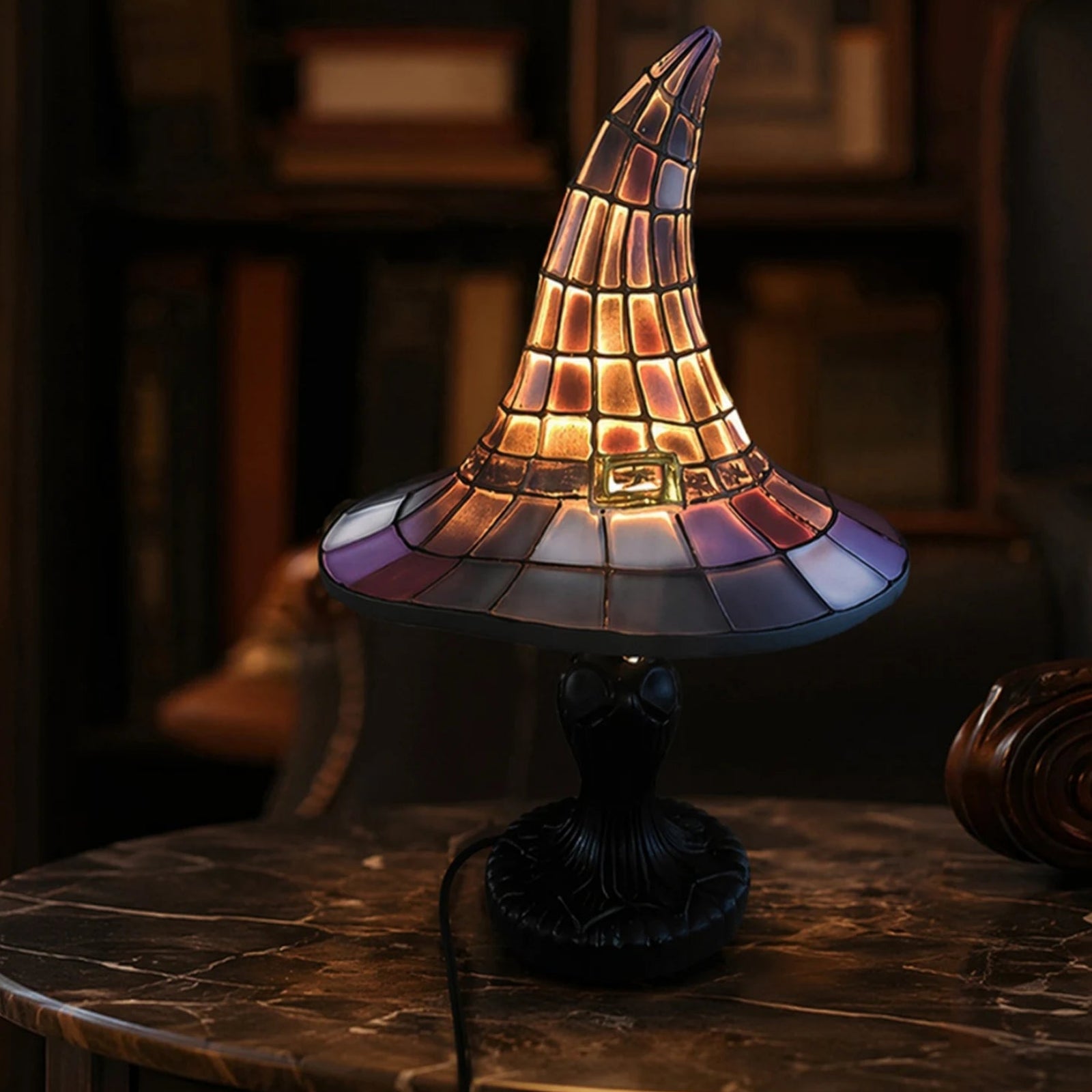 Witch hat night light lamp glowing on marble side table in cozy room