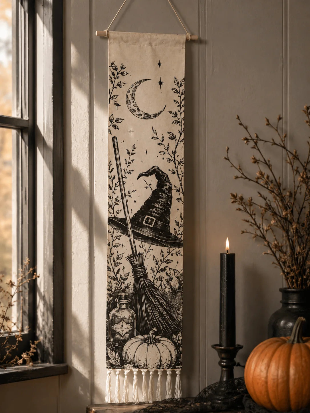 Halloween witch hat broom tapestry with moon design by window with pumpkins