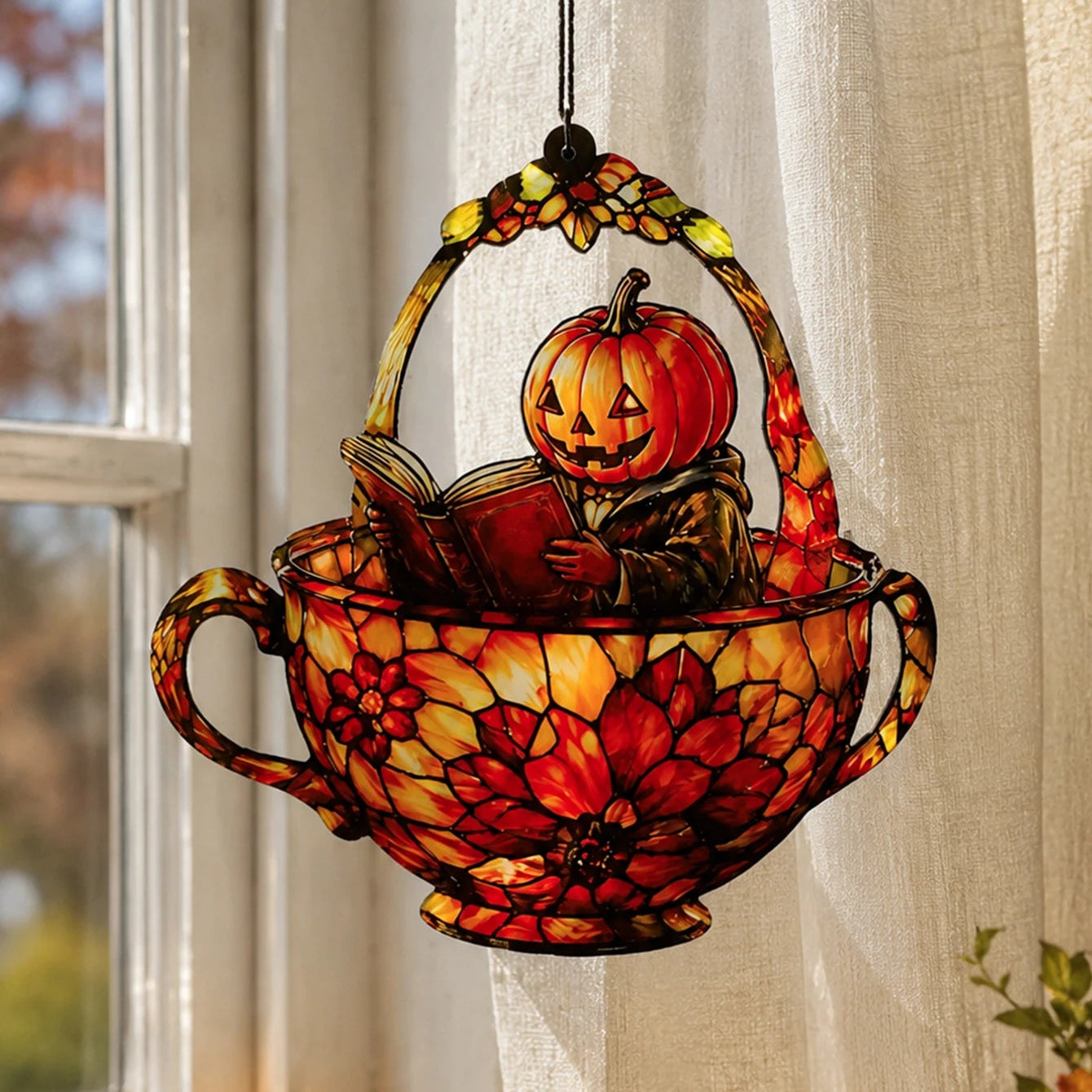 Halloween pumpkin man teacup suncatcher hanging with sheer curtains by window