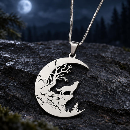 Reverse-side view of the silver Howling Wolf Crescent Moon Necklace and chain on a dark moonlit stone background.