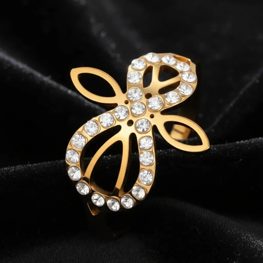 Close-up of gold Infinity Celtic knot ring with pave-set zircon stones and an open eternal-knot design on black velvet