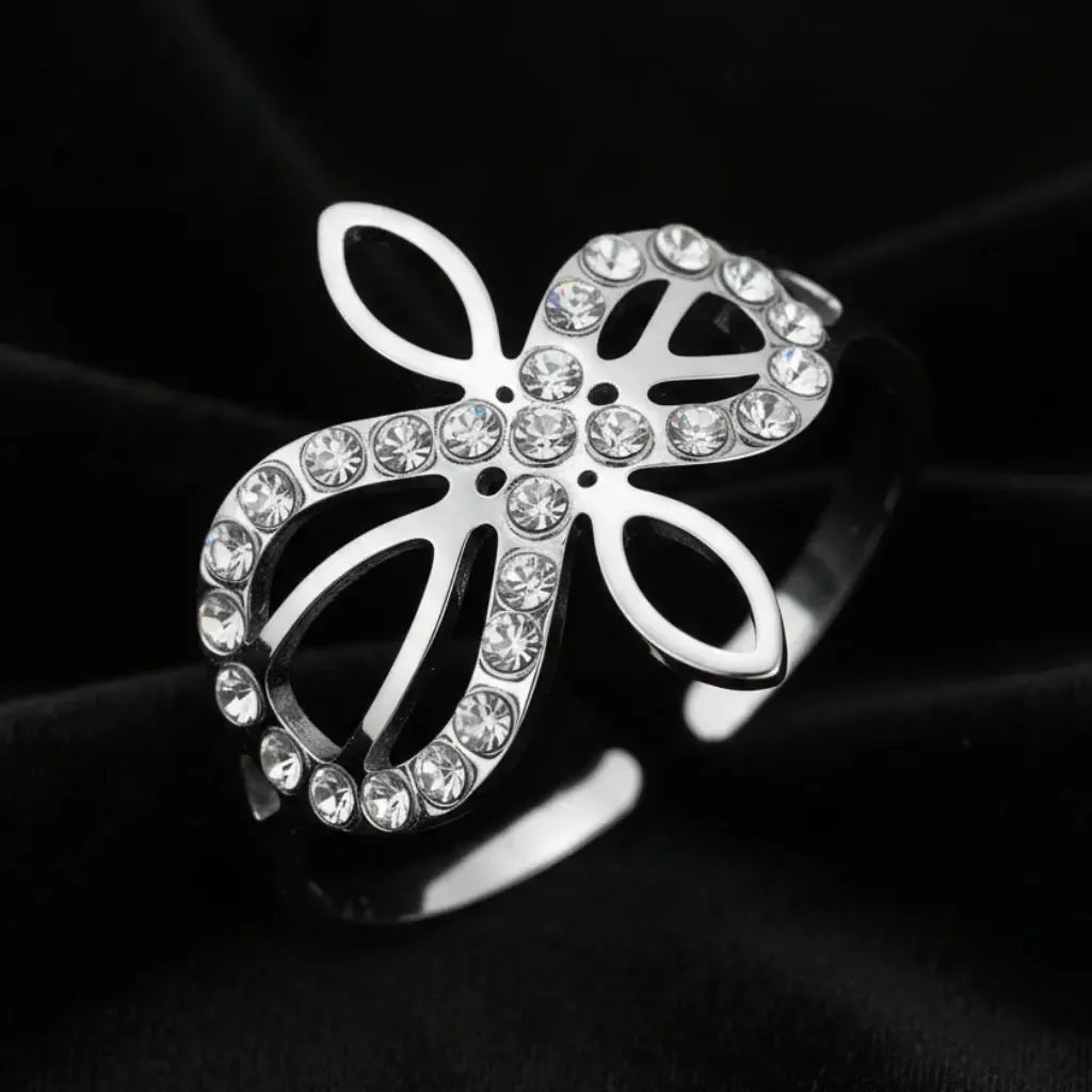 Close-up of silver Infinity Celtic knot ring with an open eternal-knot design set with sparkling clear zircon stones on black velvet