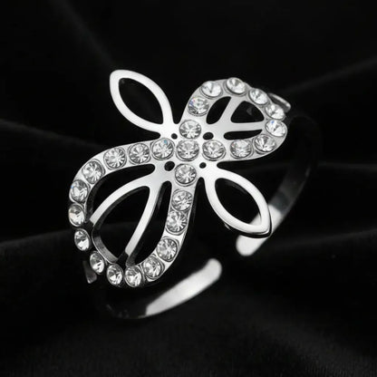 Close-up of silver Infinity Celtic knot ring with an open eternal-knot design set with sparkling clear zircon stones on black velvet
