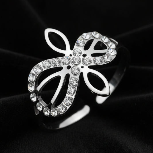 Close-up of silver Infinity Celtic knot ring with an open eternal-knot design set with sparkling clear zircon stones on black velvet
