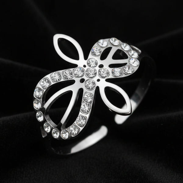 Close-up of silver Infinity Celtic knot ring with an open eternal-knot design set with sparkling clear zircon stones on black velvet