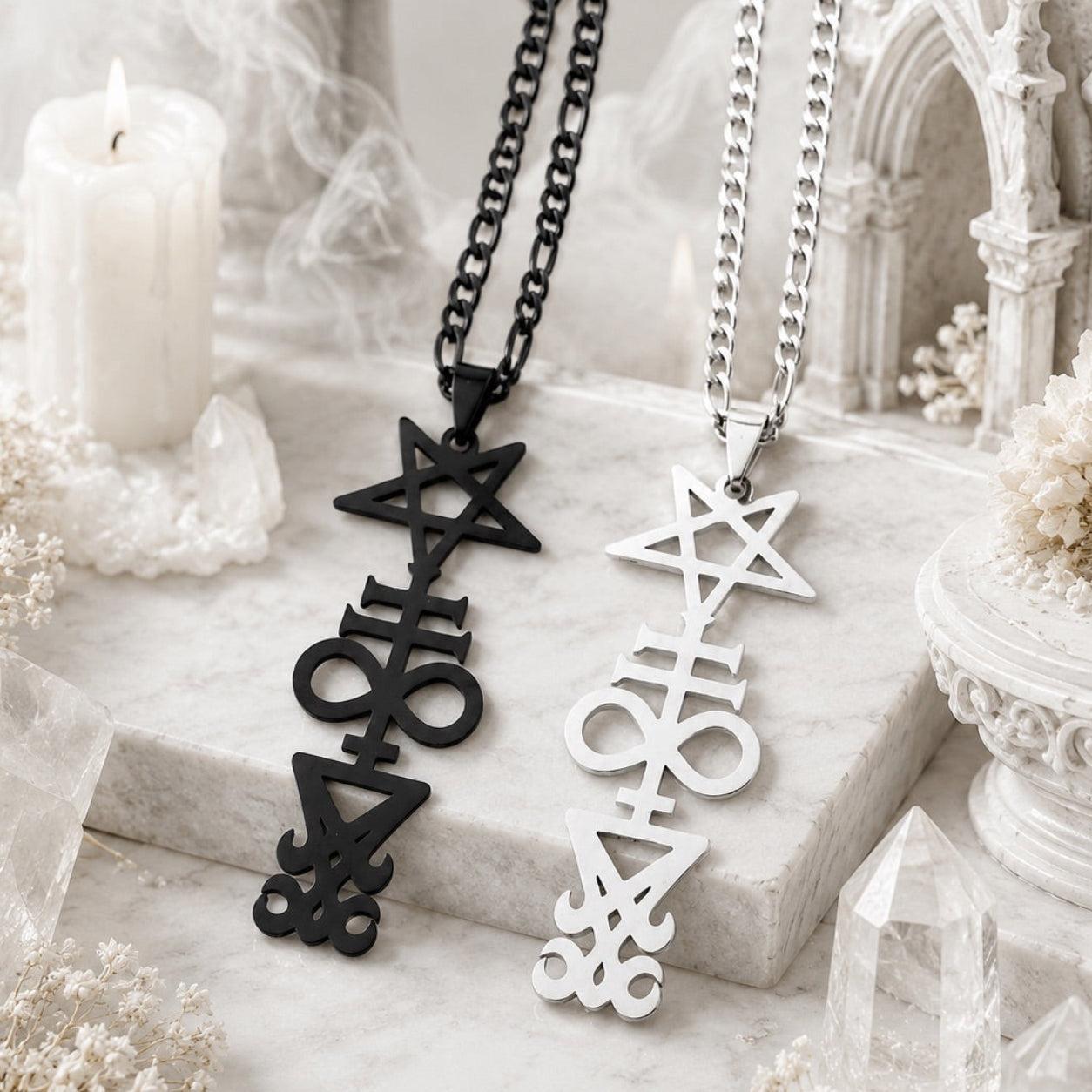 Black and silver Inverted Pentagram Cross necklaces side by side on a white marble surface with a candle, crystal points, and a gothic arch backdrop
