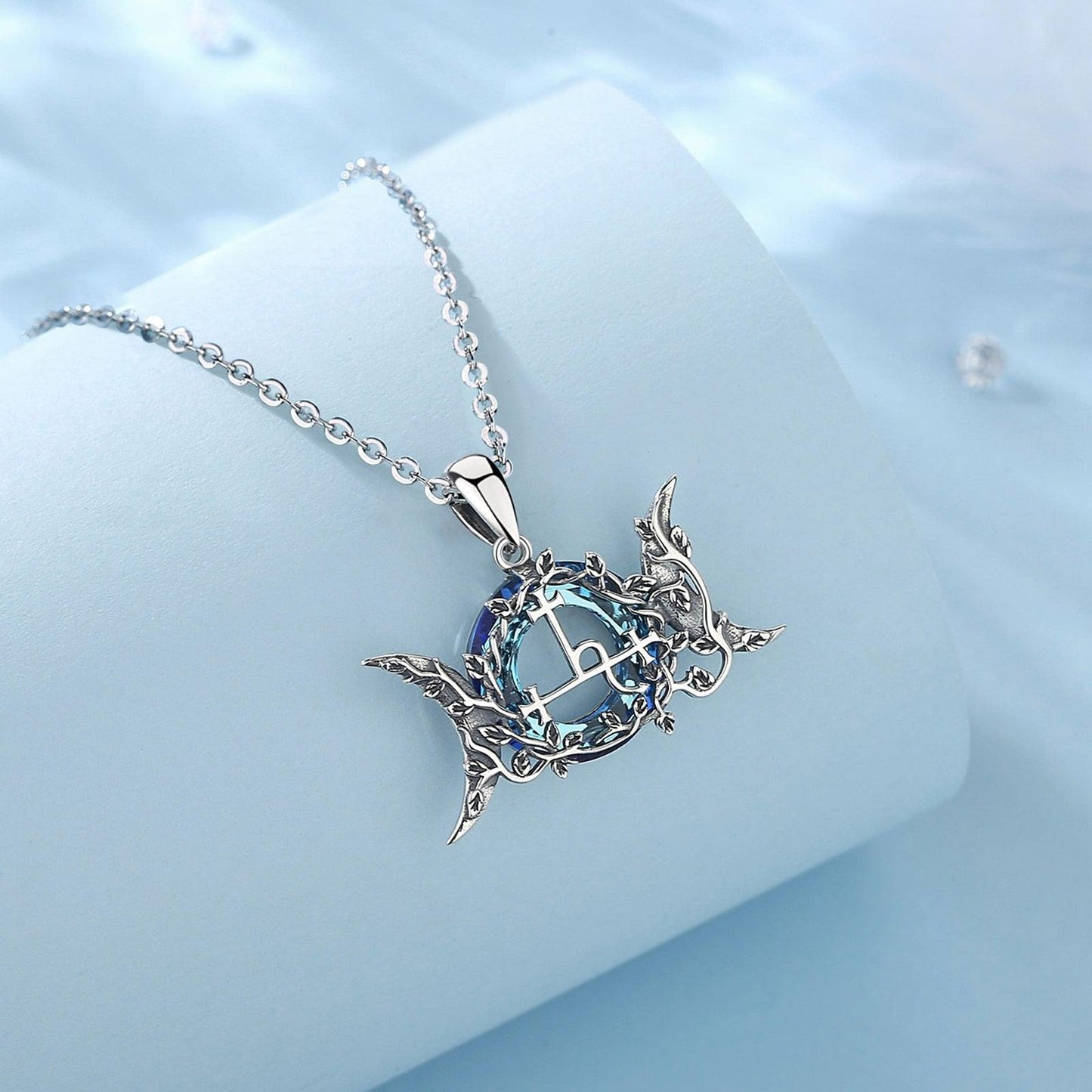 Sterling silver Lilith Moon Wicca Pagan necklace with blue crystal and intricate crescent moon design.