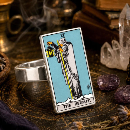 The Hermit tarot card ring in stainless steel on a brass tray with crystals and incense smoke