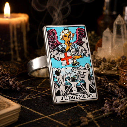 Judgement tarot card ring in stainless steel on a pentacle altar cloth with dripping candles
