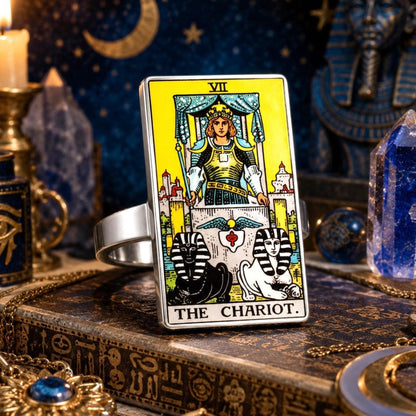 The Chariot tarot card ring in stainless steel on an antique book with blue candles and lapis stones