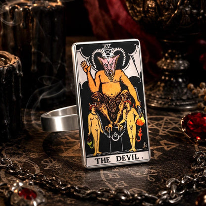 The Devil tarot card ring in stainless steel on a candlelit altar with chains and red gemstones