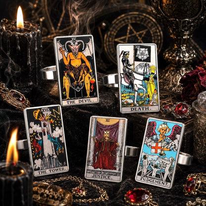 Five stainless steel tarot rings: The Devil, Death, The Tower, Justice and Judgement on a candlelit altar