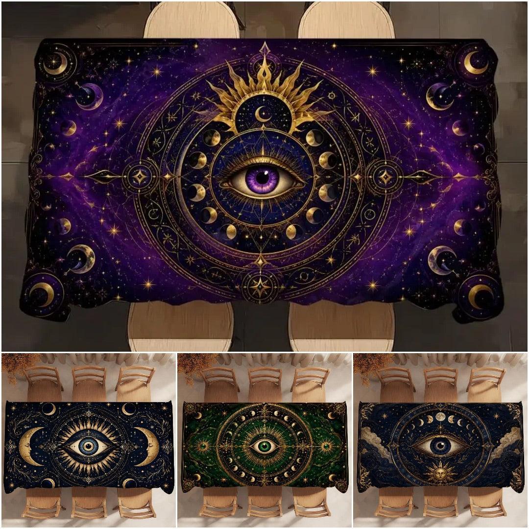A rectangular tablecloth featuring an intricate cosmic all-seeing-eye design with gold celestial motifs on a deep purple and black starry background. The main image shows the tablecloth styled on a dining table with chairs, while three smaller thumbnails at the bottom display additional color variations of the print.