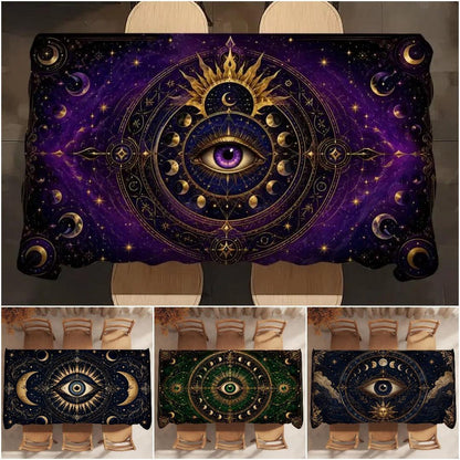 A rectangular tablecloth featuring an intricate cosmic all-seeing-eye design with gold celestial motifs on a deep purple and black starry background. The main image shows the tablecloth styled on a dining table with chairs, while three smaller thumbnails at the bottom display additional color variations of the print.