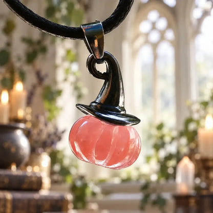Pink pumpkin witch hat pendant hanging from a cord
