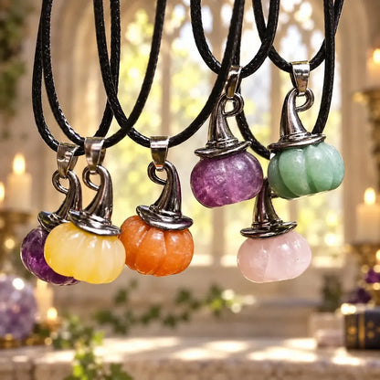 Crystal pumpkin witch hat necklaces hanging together on black cords