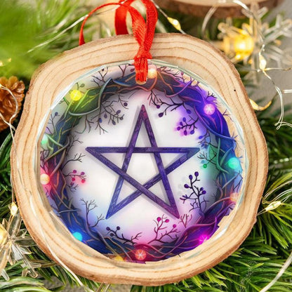 Wood-framed glass ornament with a purple pentagram, surrounded by colorful, glowing branches, hanging by a red ribbon.