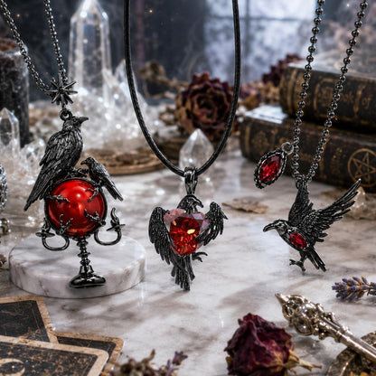 Gothic-style jewelry with ravens and red gemstones on a mystical background.