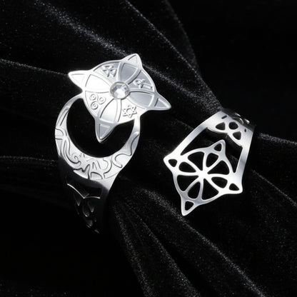 Silver crescent moon witch ring close-up on dark satin, showing the celtic knotwork cutout, engraved lunar band, and star medallion set with a clear stone.