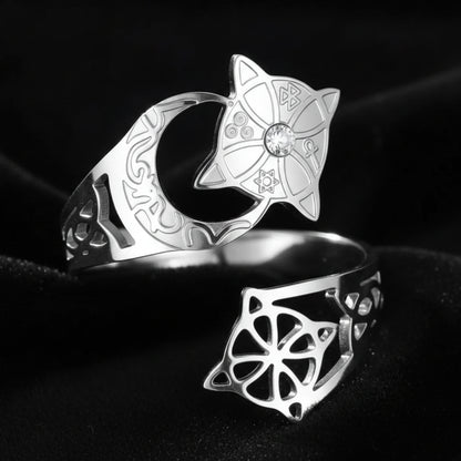 Silver Celtic knot crescent moon ring in an elevated top-down view, showing the engraved lunar band, star medallion with clear stone, and open celtic knot cutout on the adjustable open band.