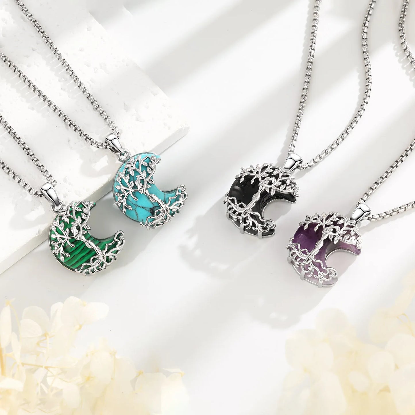 Four Tree of Life crescent moon necklaces in malachite, turquoise, obsidian and amethyst stone colors