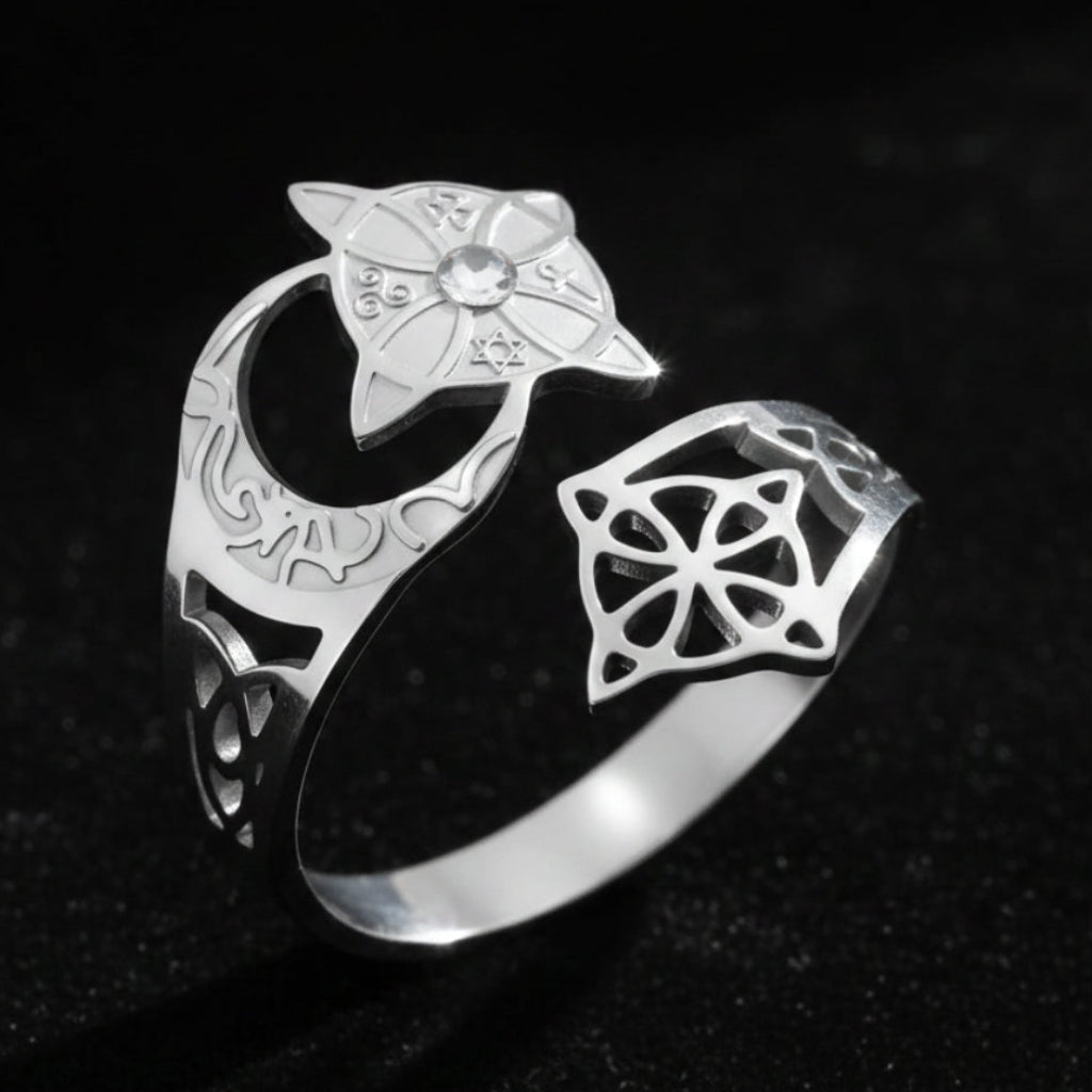 Silver Celtic knot crescent moon ring, showing the engraved lunar band, star-shaped medallion set with a clear stone, and open celtic knot cutout design.