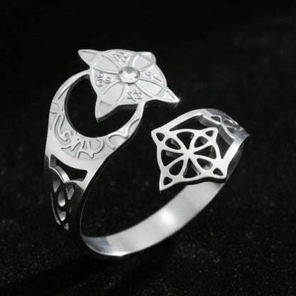 Silver Celtic knot crescent moon ring, showing the engraved lunar band, star-shaped medallion set with a clear stone, and open celtic knot cutout design.