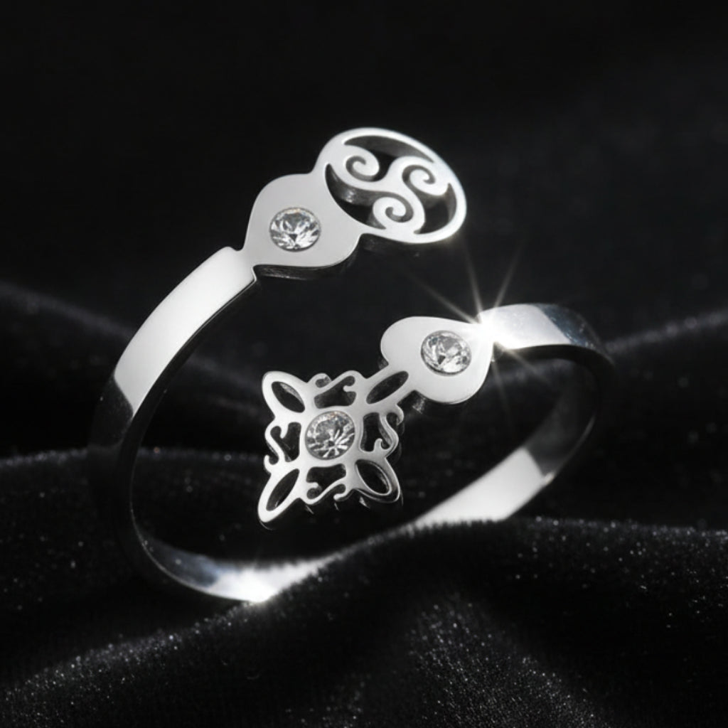 Close-up of silver Triskele Triple Spiral open ring with Celtic witch knot charm and sparkling zircon stones