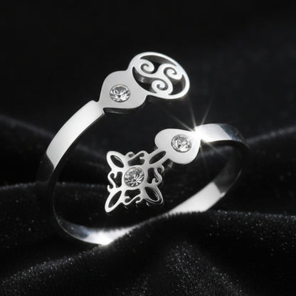 Close-up of silver Triskele Triple Spiral open ring with Celtic witch knot charm and sparkling zircon stones