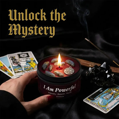 Hand holding Scorpio Candle I Am Powerful with tarot cards, incense stick and a black obsidian crystal cluster - Unlock the Mystery