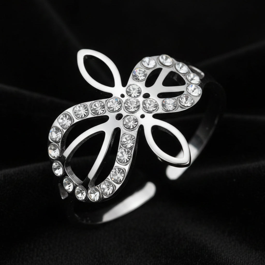 Close-up of silver Infinity Celtic knot ring with an open eternal-knot design set with sparkling clear zircon stones on black velvet