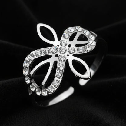 Close-up of silver Infinity Celtic knot ring with an open eternal-knot design set with sparkling clear zircon stones on black velvet