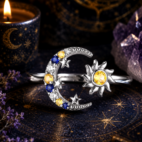 Silver ring with moon and sun design on a dark background with candles and crystals.