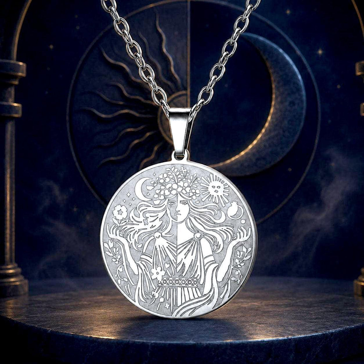 A silver pendant necklace featuring an intricately engraved celestial design with a woman, sun, moon, and stars, displayed on a dark, mystical background with a crescent moon and sun motif.