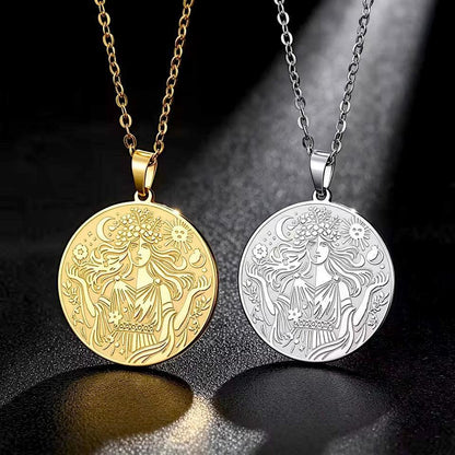 Two round pendant necklaces displayed side by side on a dark reflective surface. One pendant is gold-toned and the other is silver-toned, both featuring an engraved female figure with flowing hair and floral details, hanging from matching chain styles.