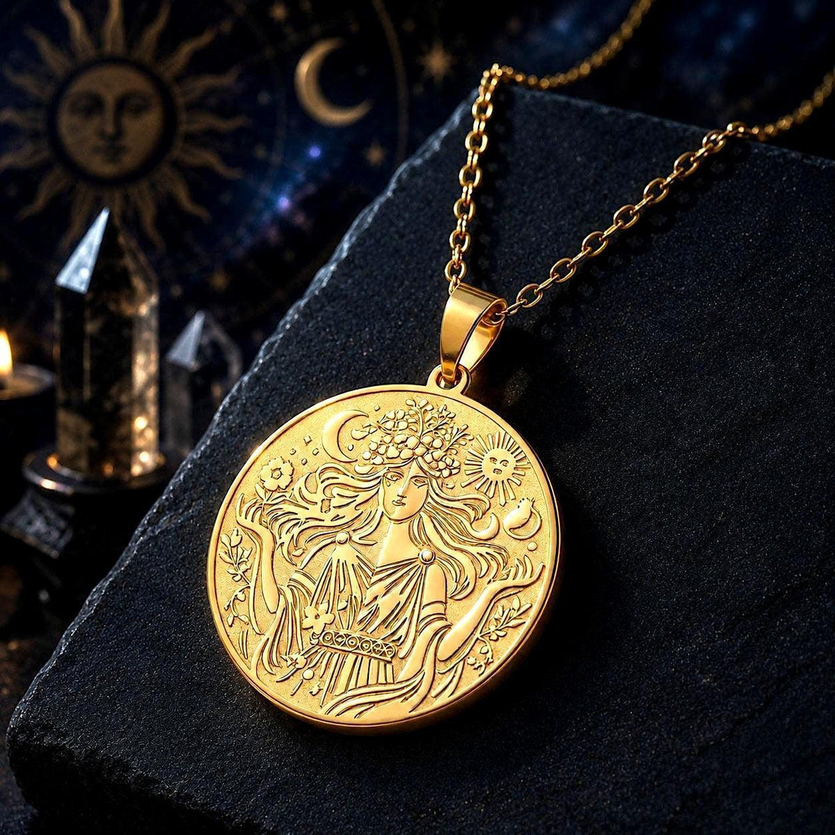 A gold-toned circular pendant necklace with an embossed celestial design of a woman under a crescent moon and sun, displayed on a dark textured stone slab with mystical background props.