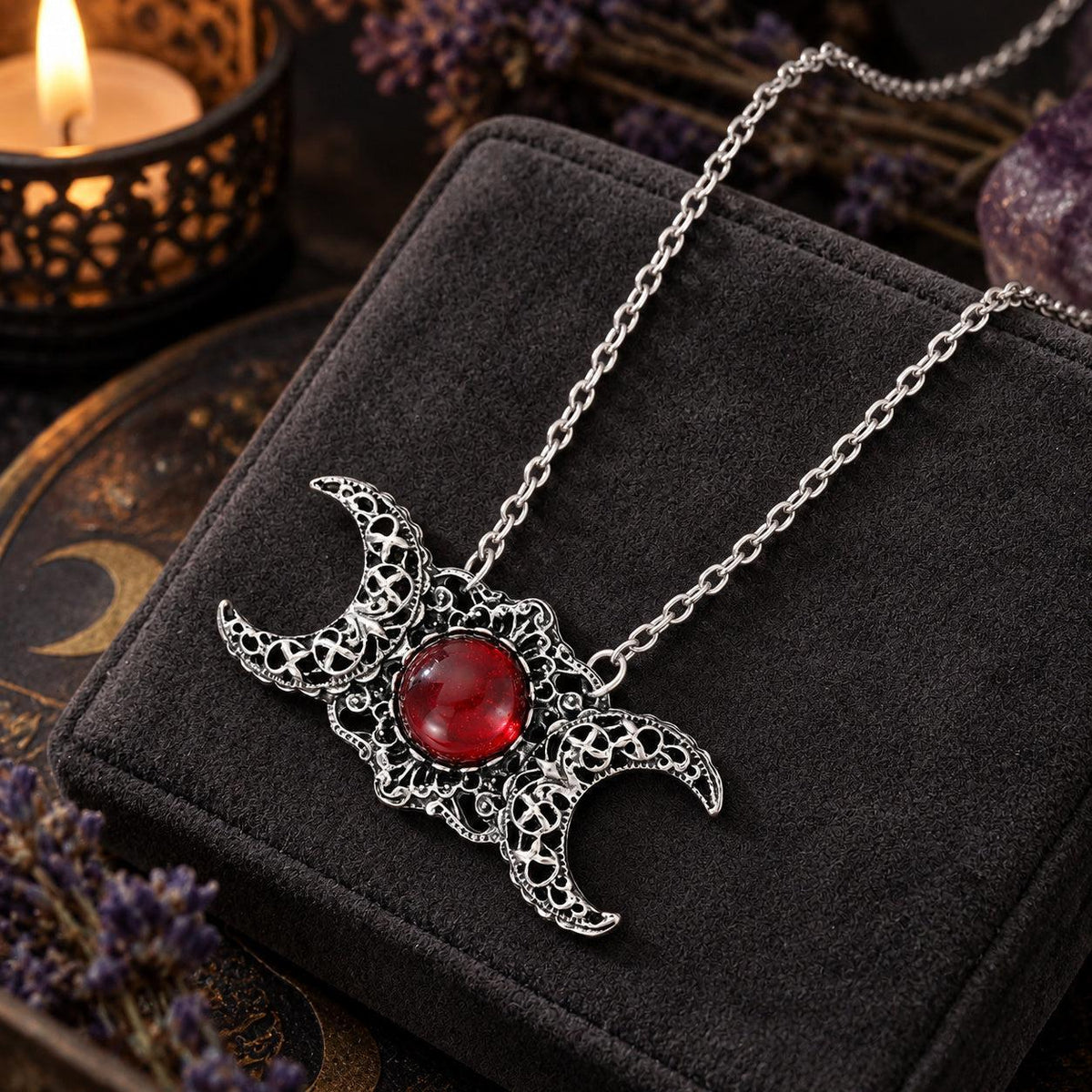 Triple Moon Goddess necklace with red center stone in dark Wiccan scene, view 2
