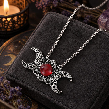 Triple Moon Goddess necklace with red center stone in dark Wiccan scene, view 2