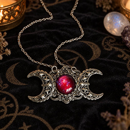 Triple Moon Goddess necklace with red center stone in dark Wiccan scene, view 1