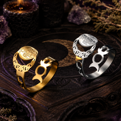 Gold and silver Triple Moon Goddess adjustable rings on a dark Wicca altar