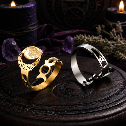 Gold and dark steel Triple Moon Goddess adjustable rings on a dark altar