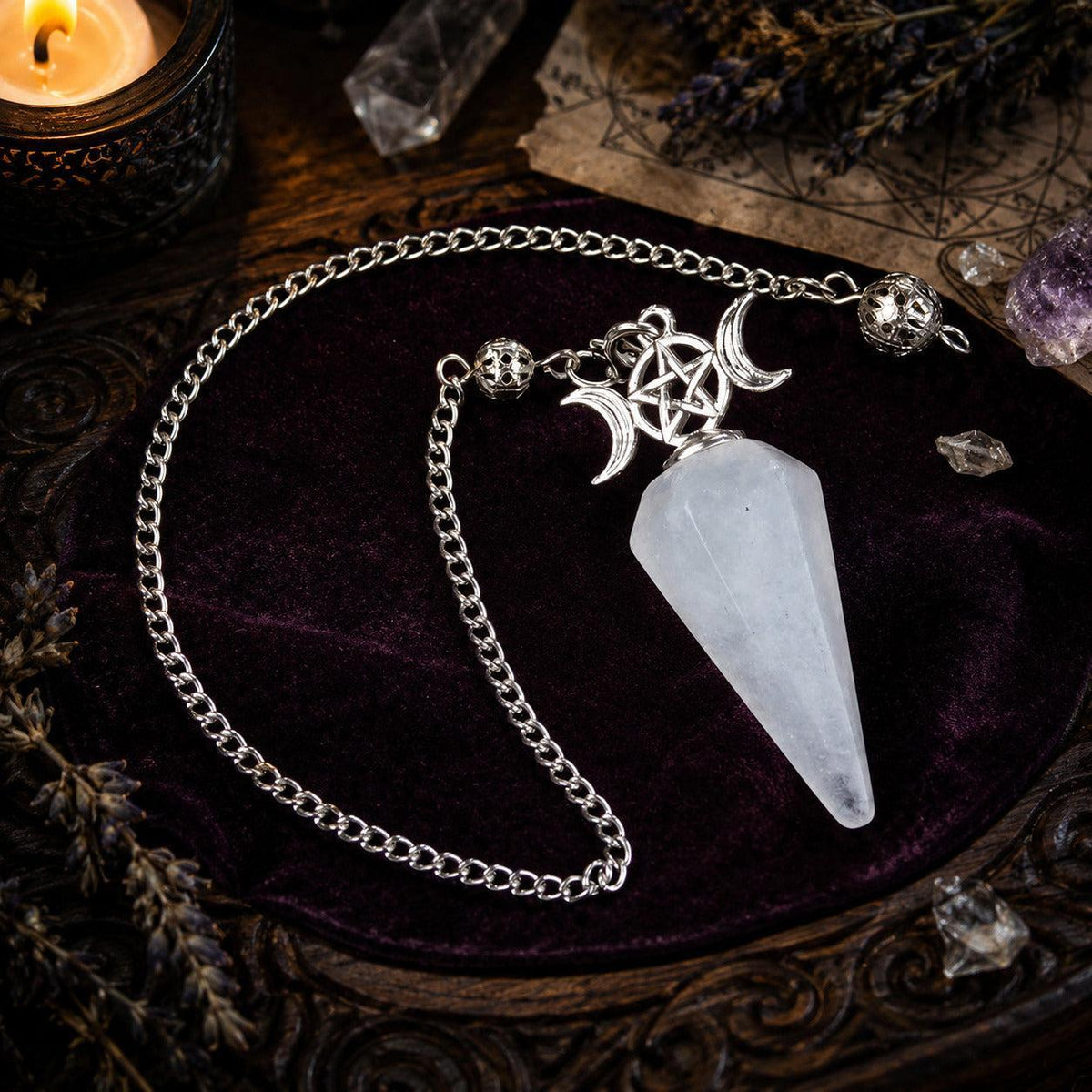 White crystal Triple Moon pendulum on a candlelit Wiccan ritual altar