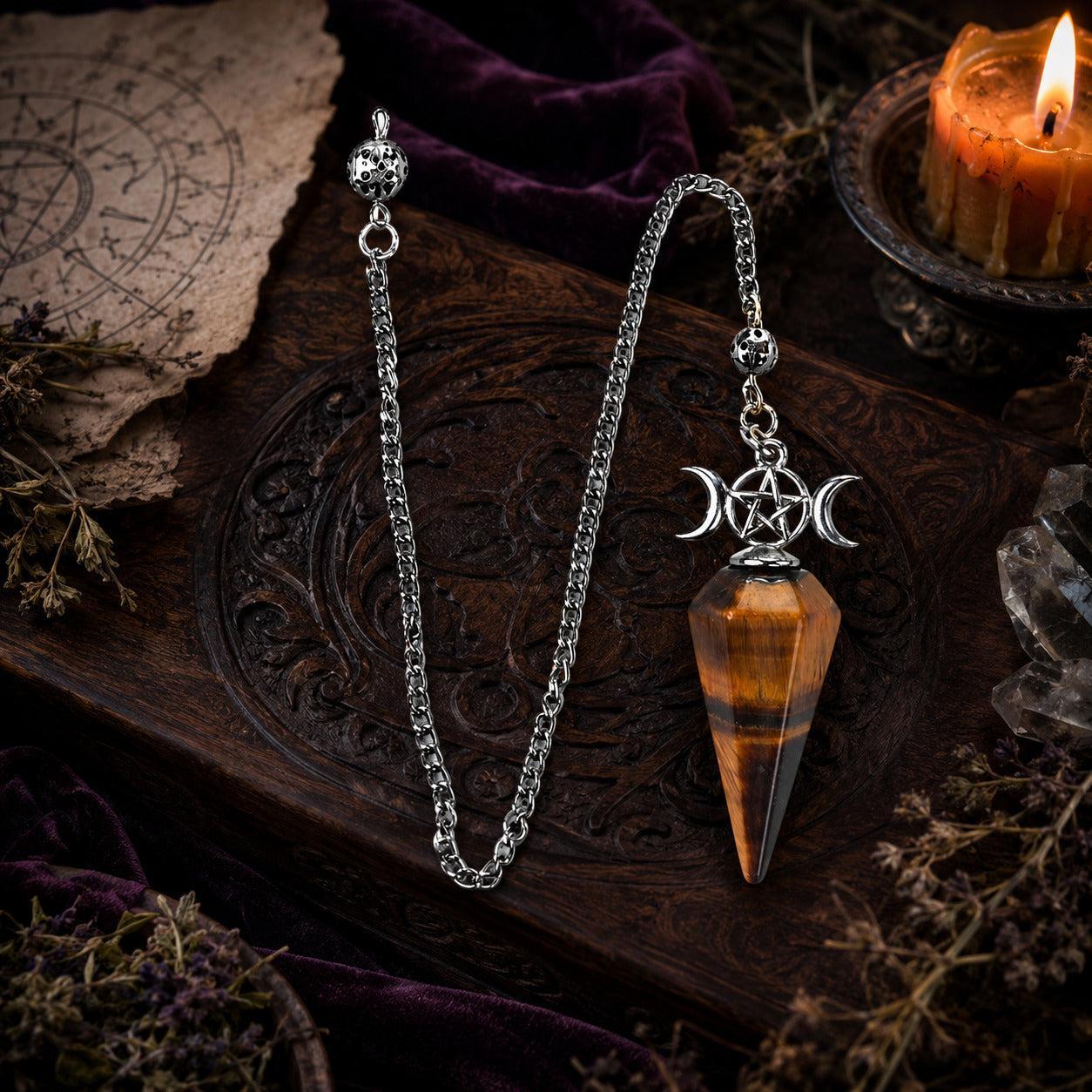 Tiger eye Triple Moon pendulum with complete chain details on a Wiccan altar