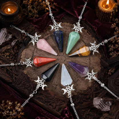 Eight Triple Moon crystal pendulums arranged on a candlelit Wiccan ritual altar