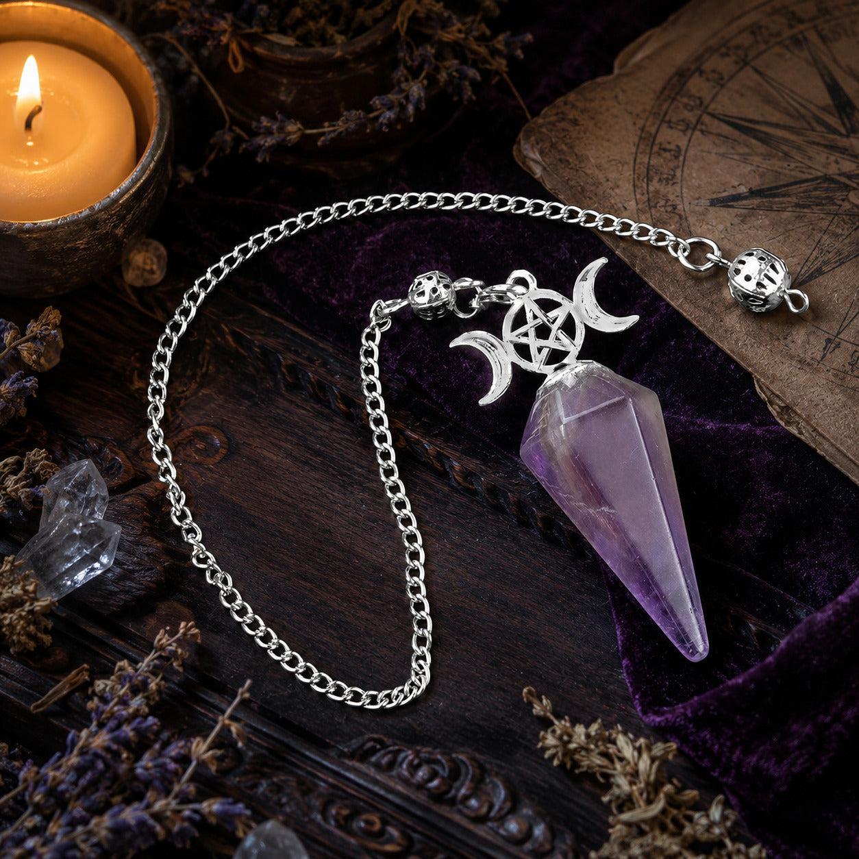 Amethyst Triple Moon crystal pendulum on a Wiccan ritual altar