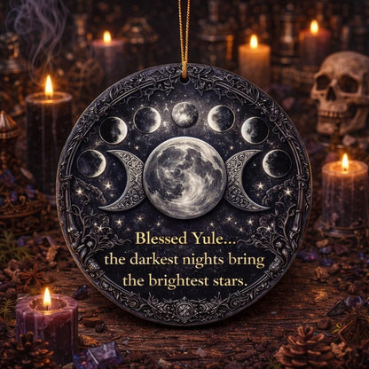 Dark ceramic Triple Moon & Moon Phase Yule ornament with "Blessed Yule" text, surrounded by lit candles.