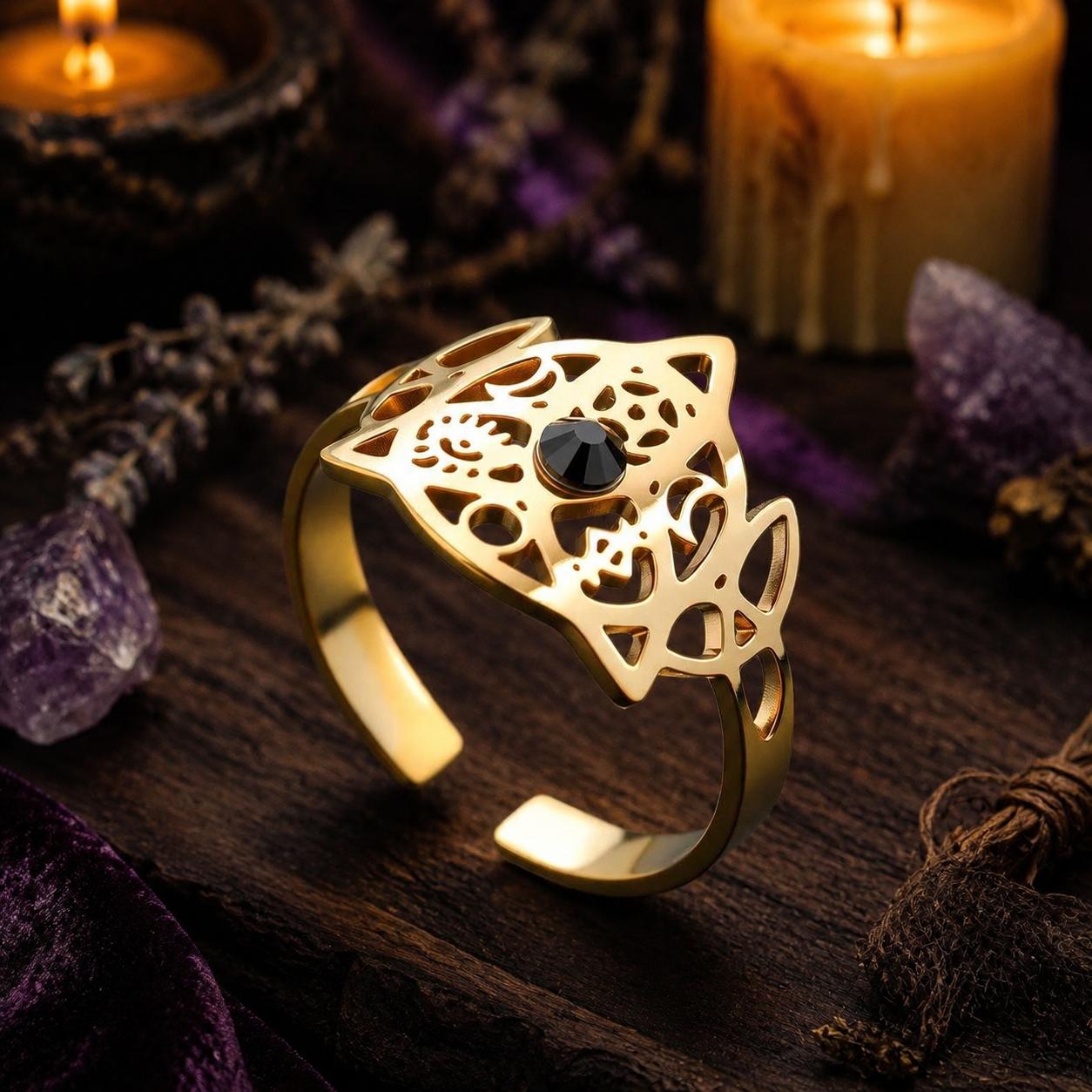 Gold Trinity Knot open ring angled view with candles and amethyst