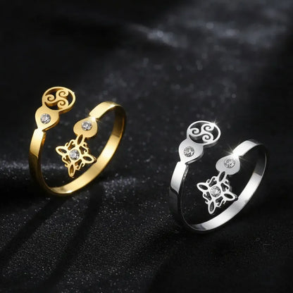 Gold and silver Triskele Triple Spiral open rings side by side, showing Celtic witch knot charm and clear zircon stones
